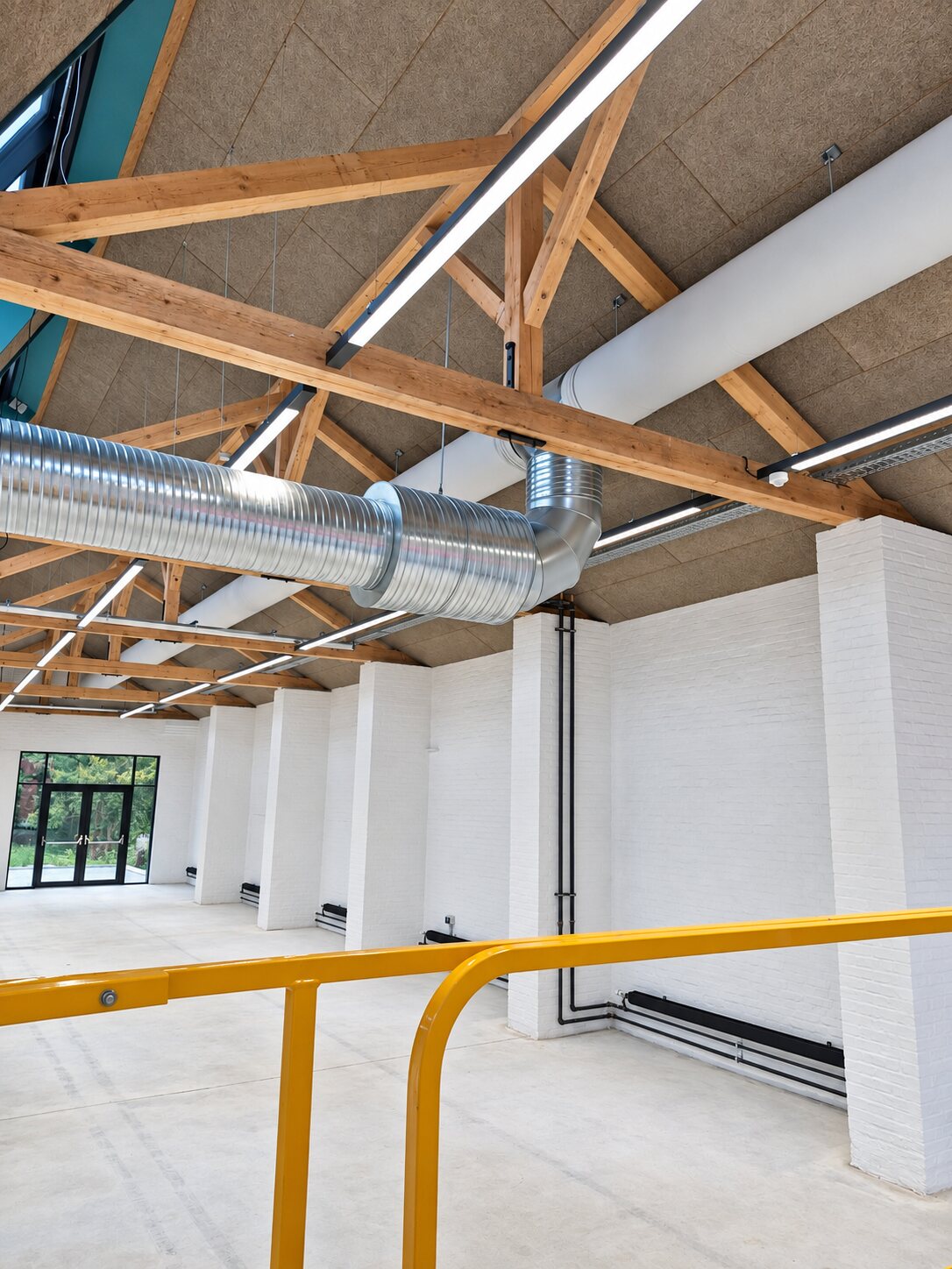Ny ventilationsinstallation med synlige kanaler i lyst lokale